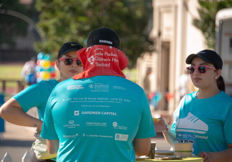 The back of a summer scamper t shirt with all the sponsors logos showing.