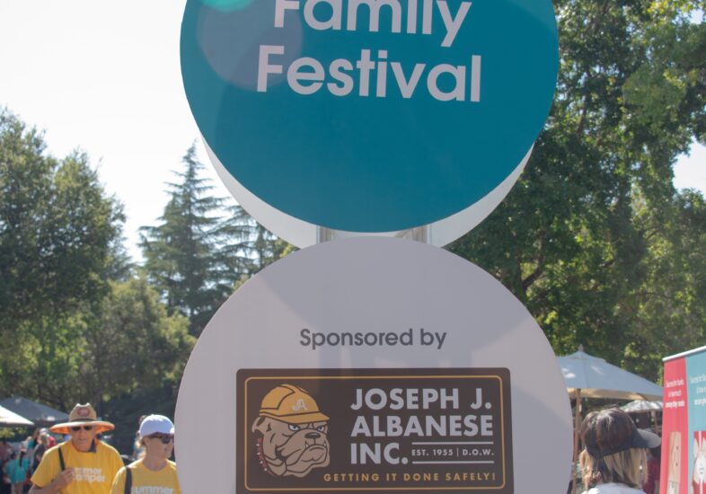 A sign for the Summer Scamper family festival above a sign showing the sponsor Joseph J Albanese Inc.